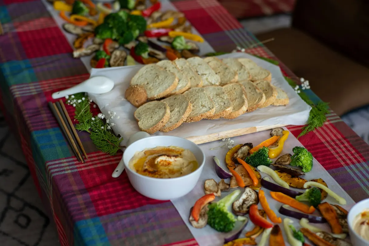 Стол на природе с закусками, хлебом и овощами-гриль